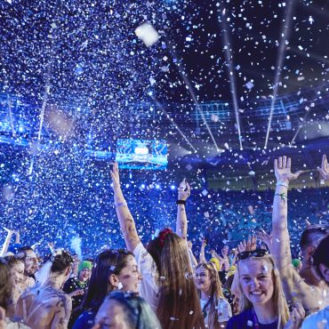 Photo of people smiling with confetti in the air