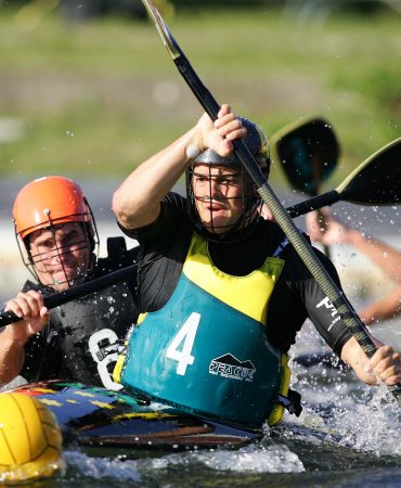 Photo of men in kayaks fighting over ball in water