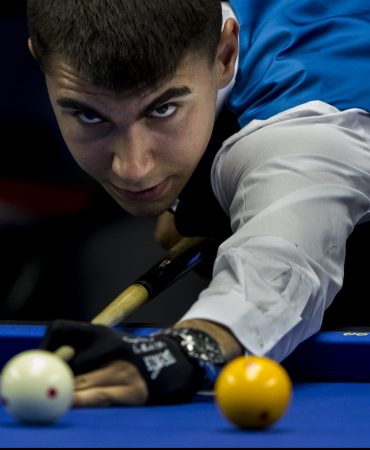 Photo of man taking aim on billiards table